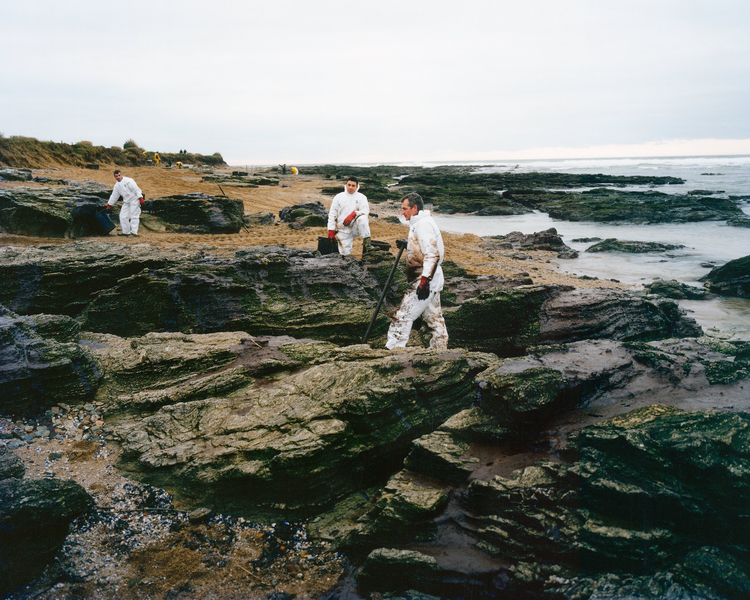 Hexagone 2 — The Landscape Consumed — Volunteers cleaning up the oil spill on the shore at Pointe de Saint-Gildas, Loire-Atlantique, 2000